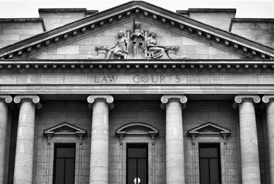 A courthouse with the words "LAW COURTS" engraved above the entrance. It features large columns and sculptures of figures holding a scale, symbolizing justice, above the door.